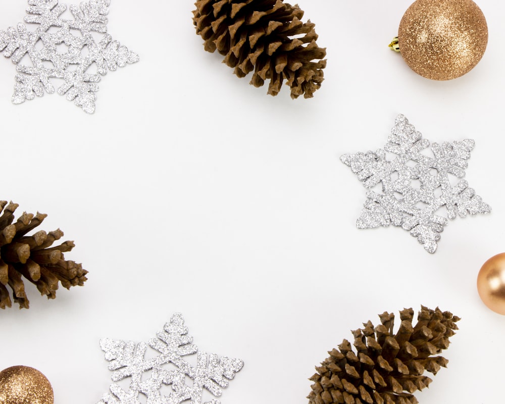 snowflake, pine cones, and baubles on white surface