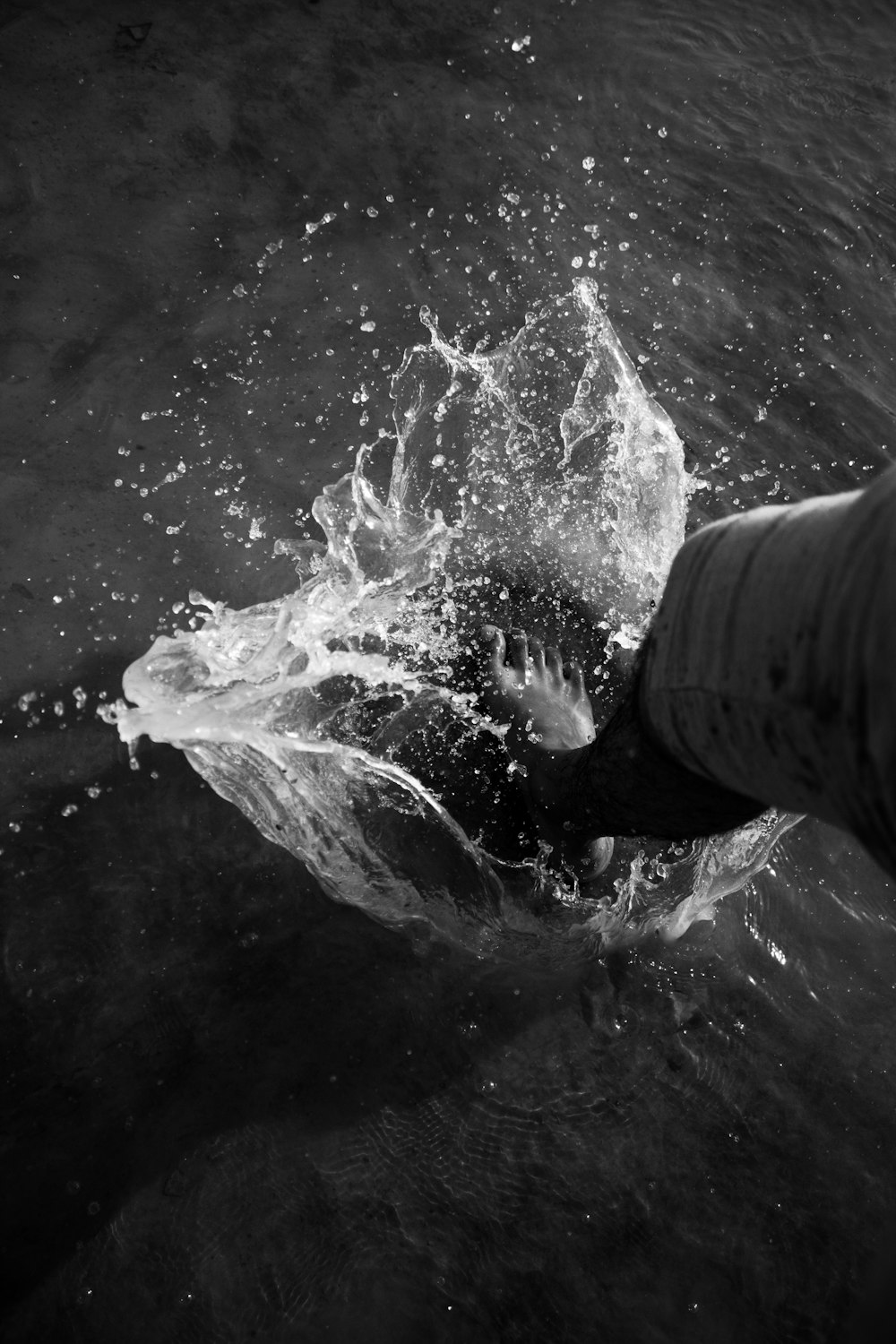 grayscale photography of person stepping on body of water