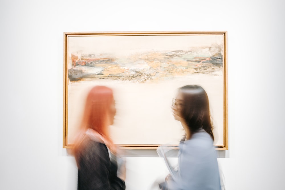 Due donne in piedi accanto alla pittura