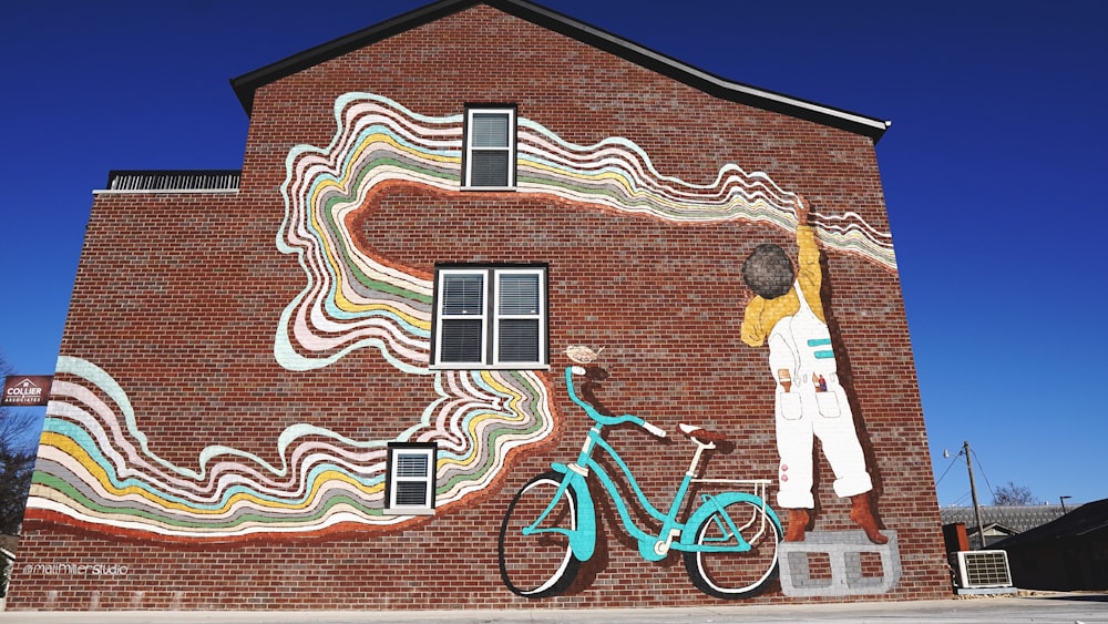 brown brick house with boy beside bicycle art