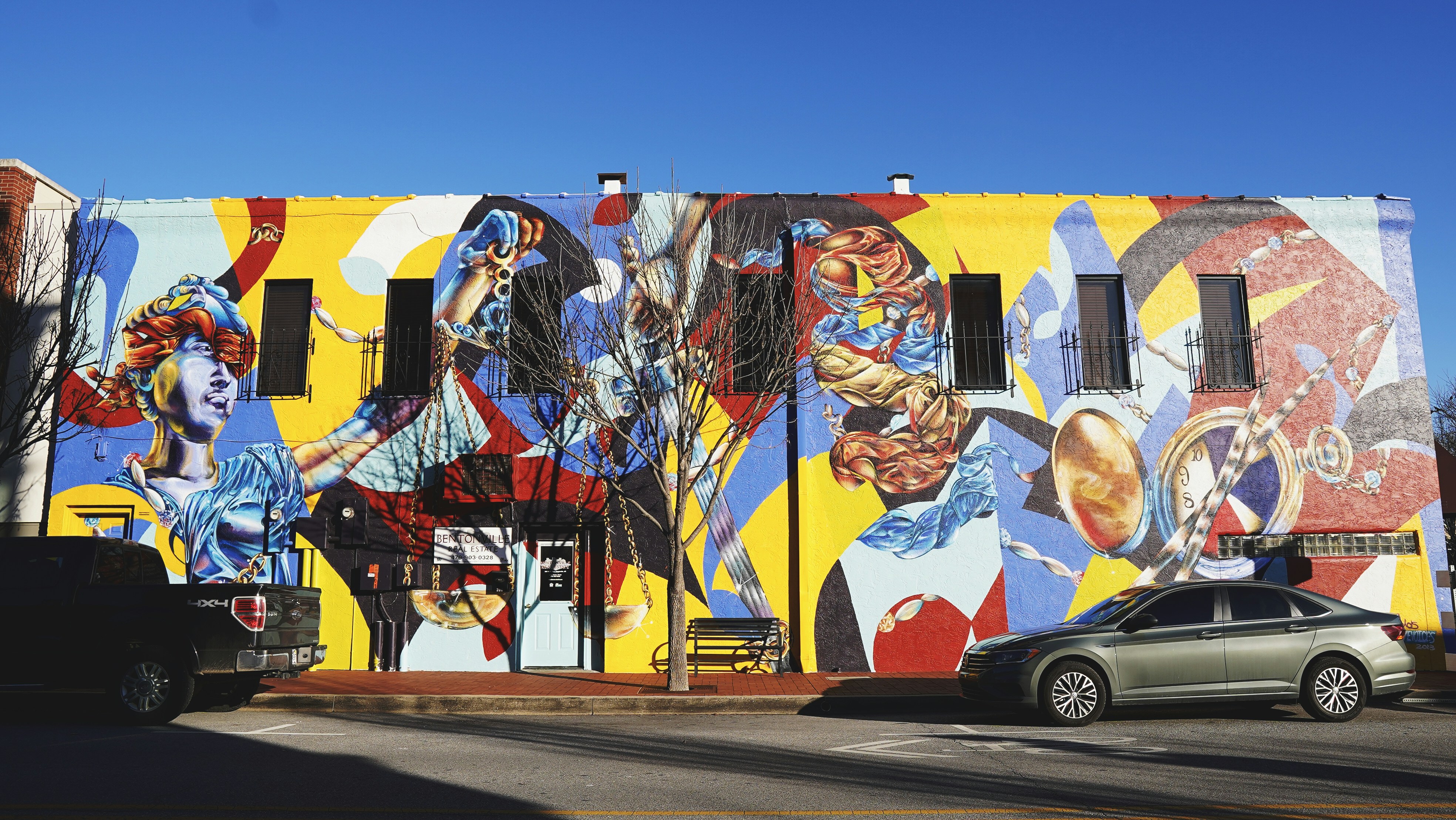 gray and black cars parked beside building with graffiti