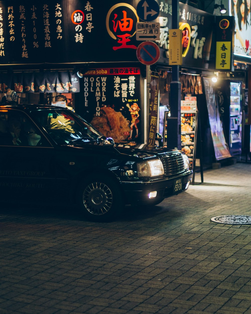 black vehicle parked beside building at night