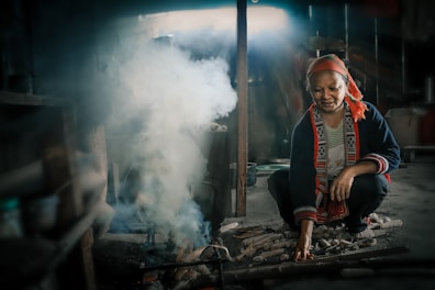 woman crouching beside smoking firewords