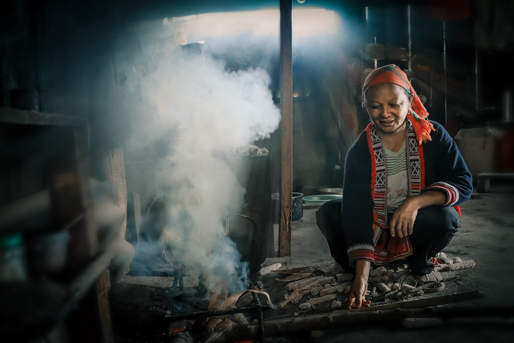 woman crouching beside smoking firewords