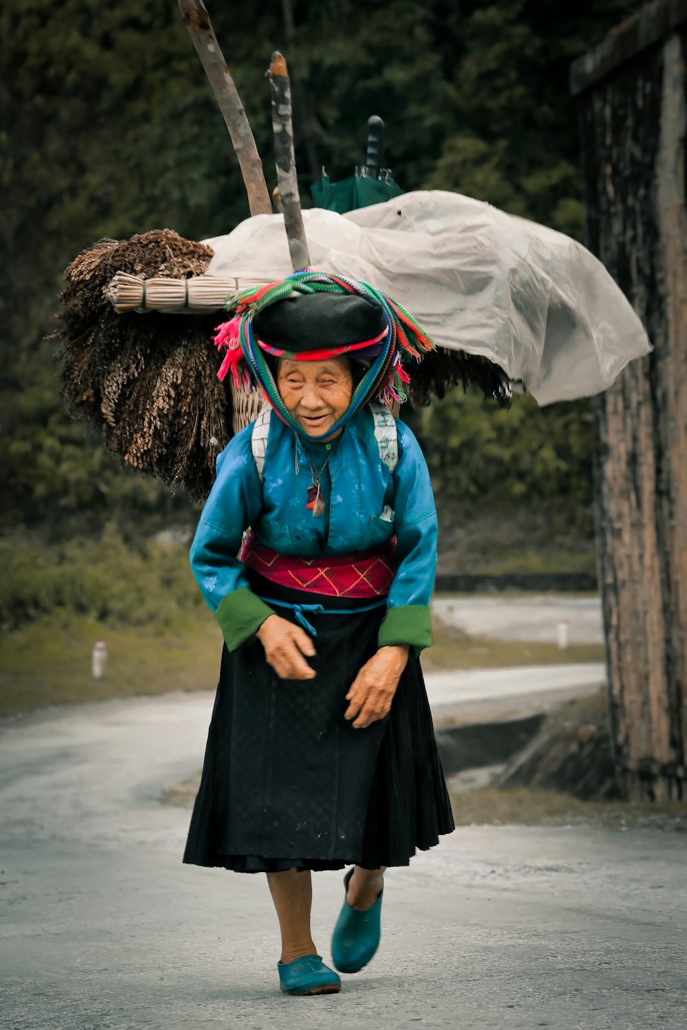 walking woman carrying woods on back