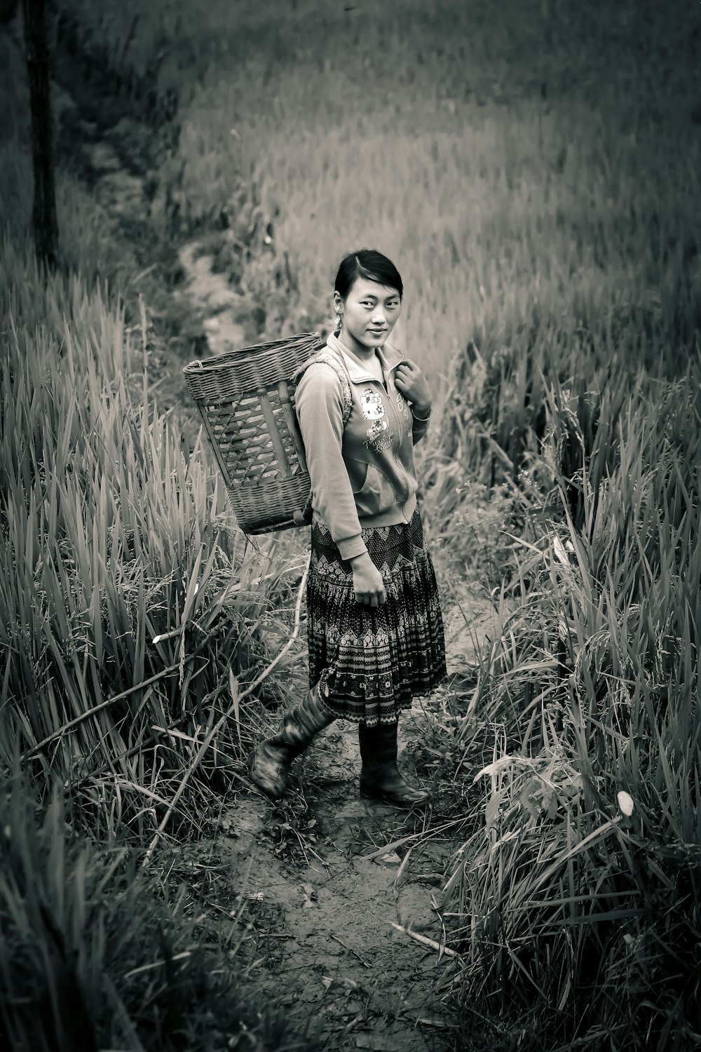 a young girl carrying a basket in a field