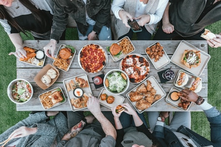 a group of people sitting around a table with food
