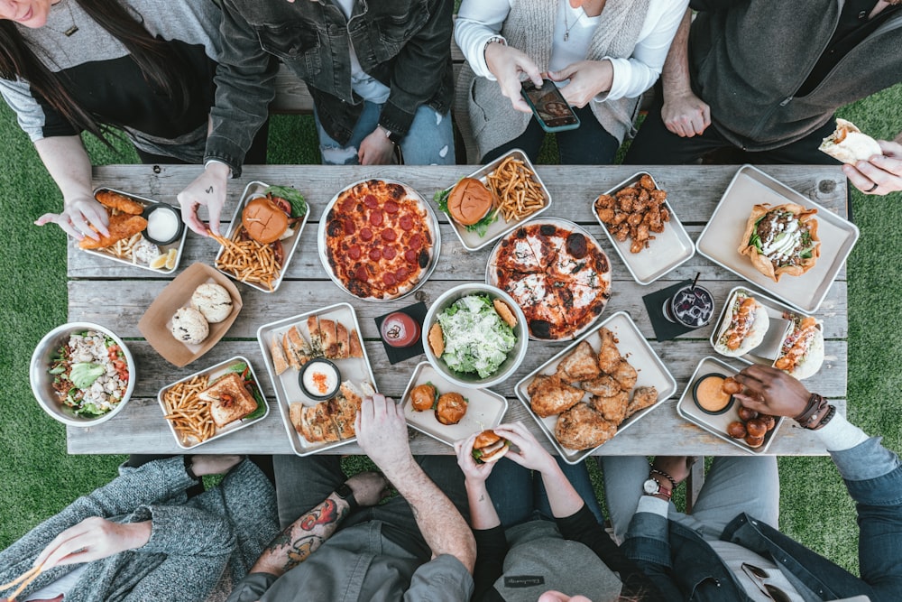 食べ物を持ってテーブルの周りに座っている人々のグループ