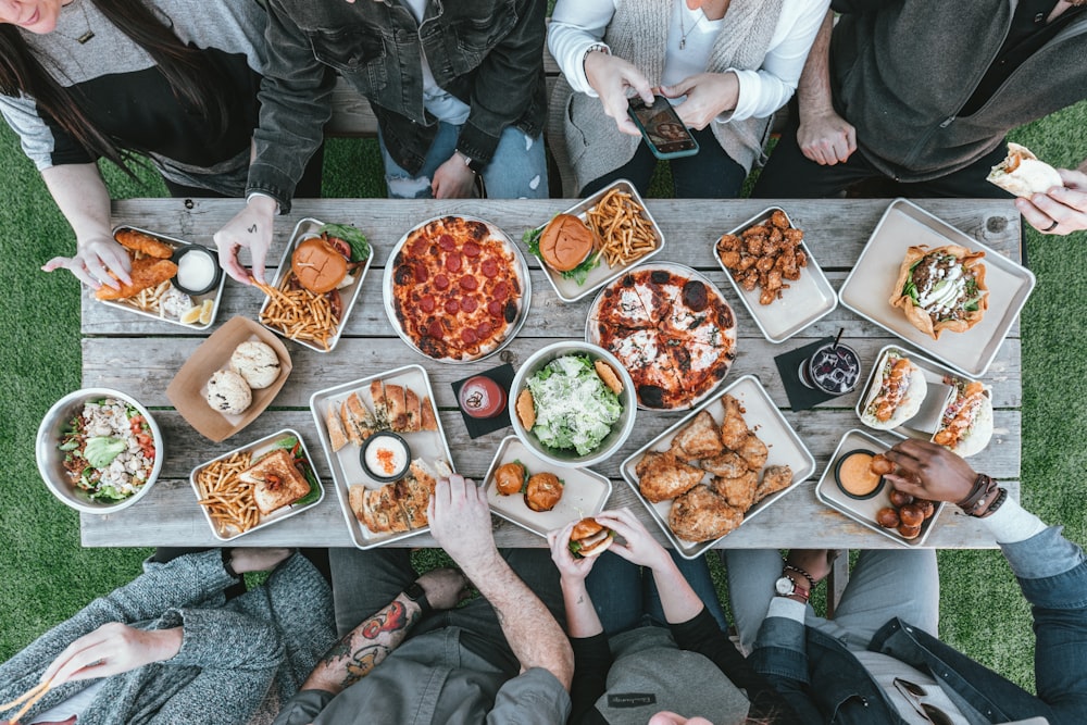 a group of people sitting around a table with food