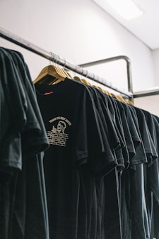 hanged black t-shirts beside wall