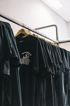 hanged black t-shirts beside wall