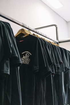 hanged black t-shirts beside wall