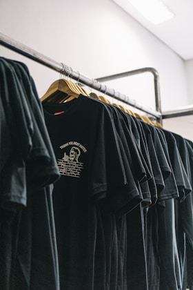 hanged black t-shirts beside wall