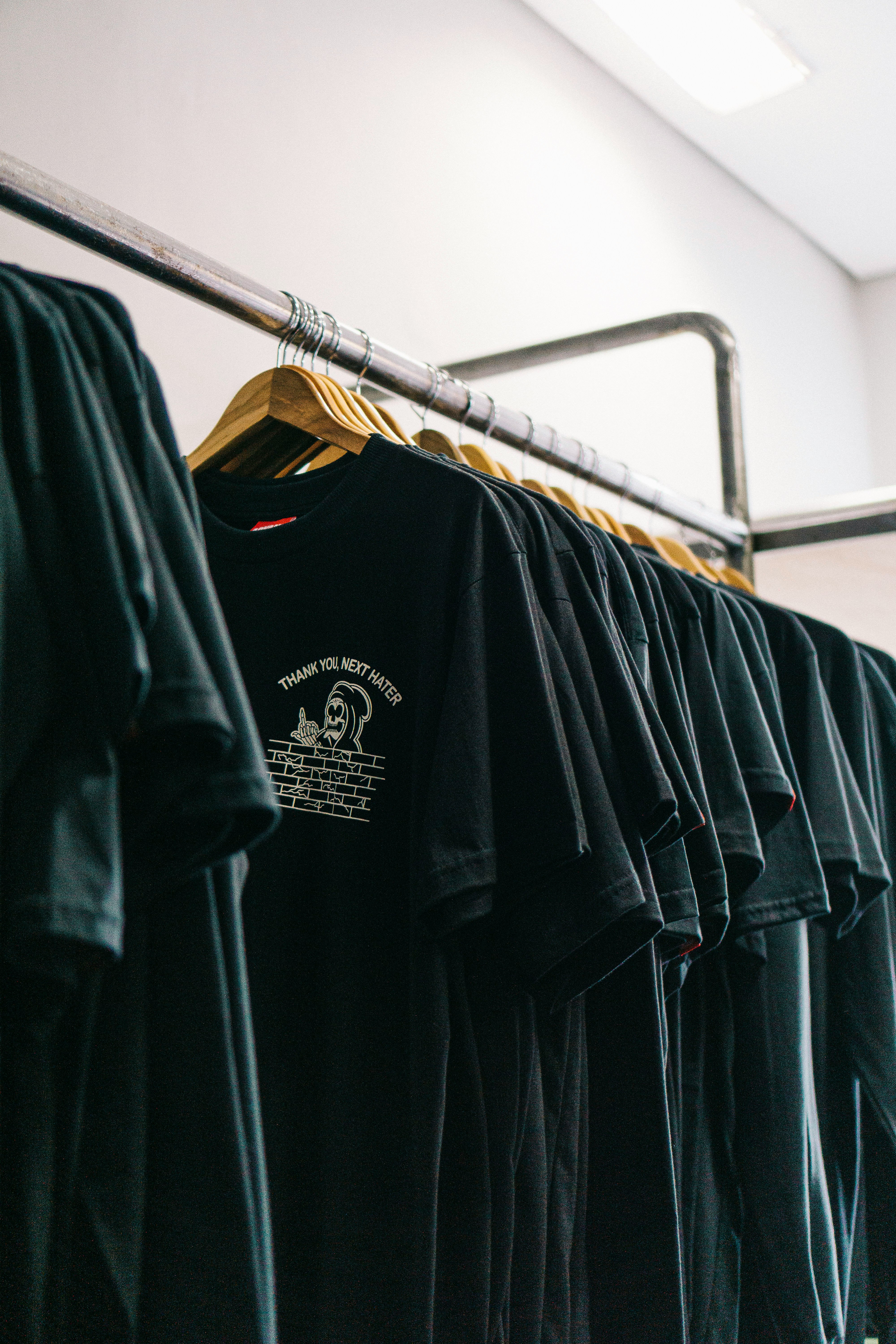 hanged black t-shirts beside wall