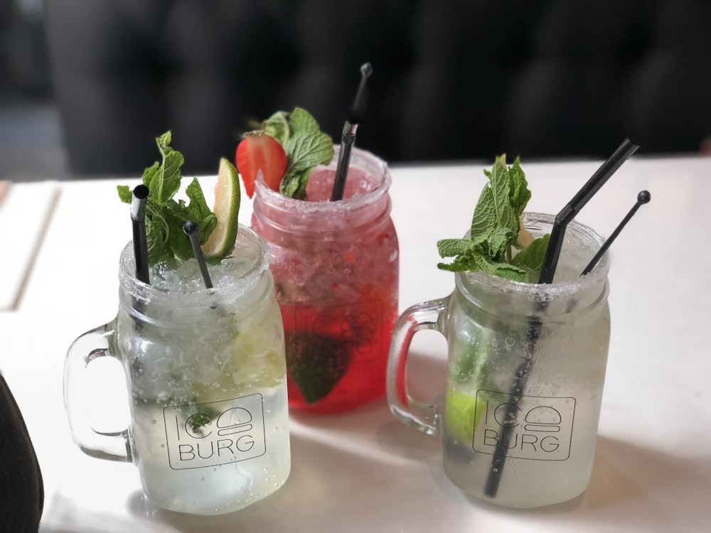 three clear jars with juices