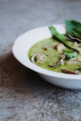 A creamy seafood chowder garnished with fresh parsley in a white bowl.