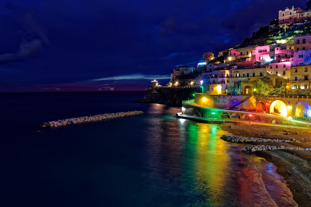 Una città illuminata di notte dall'oceano