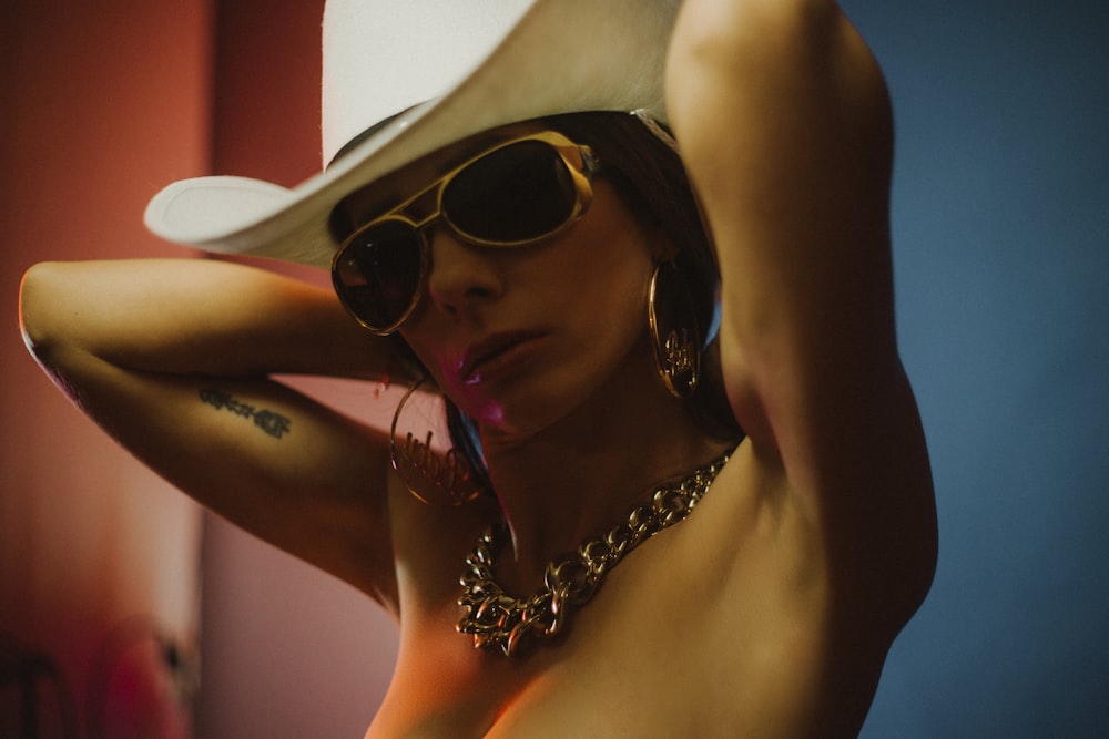 woman wearing white cowboy hat and gold-colored sunglasses
