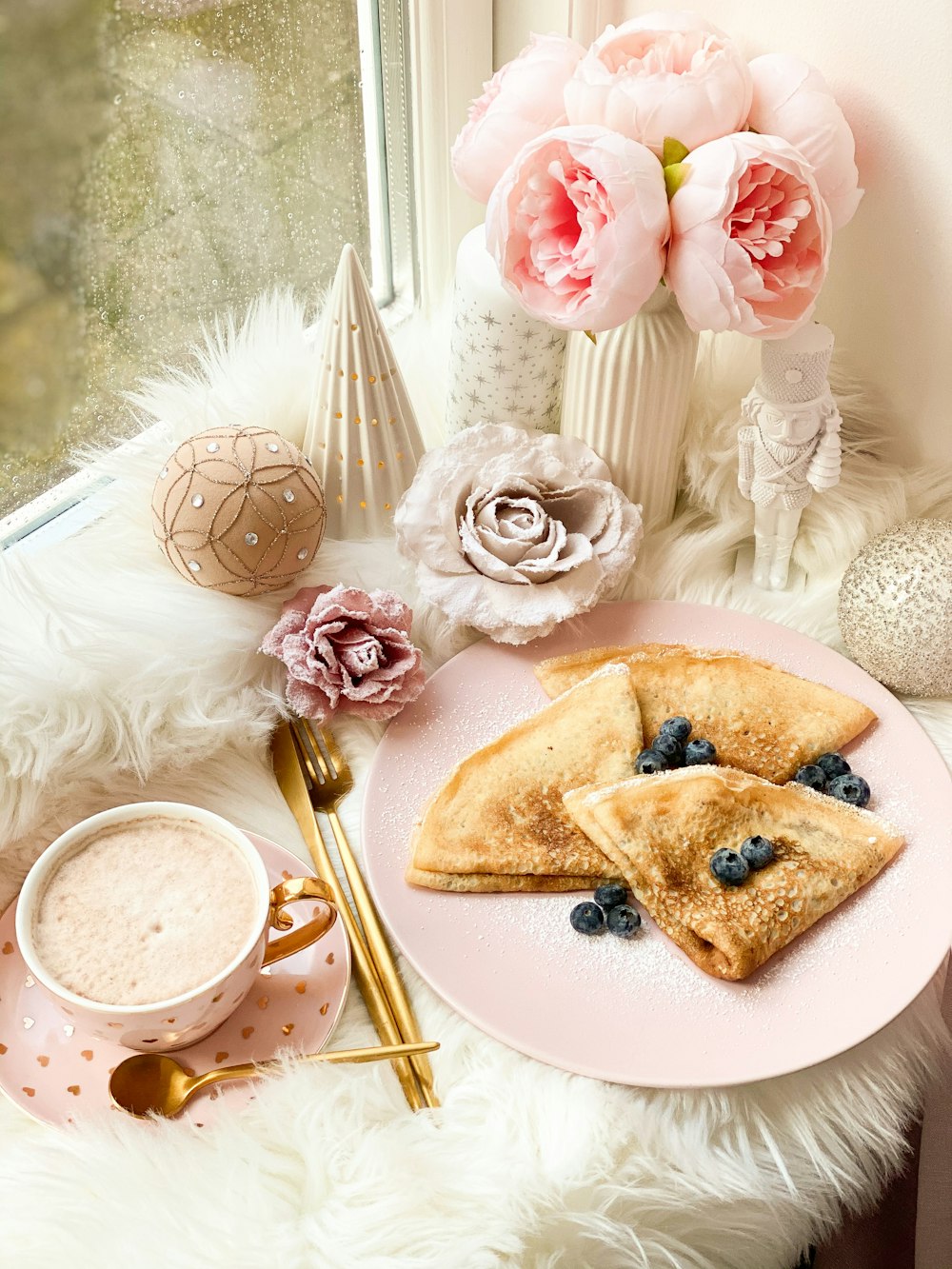 pancake with blueberries on plate beside window