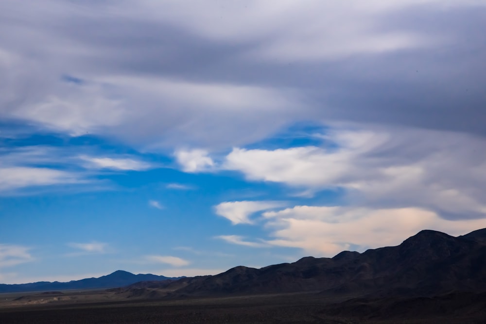 gray mountain under cloudy sky during daytime