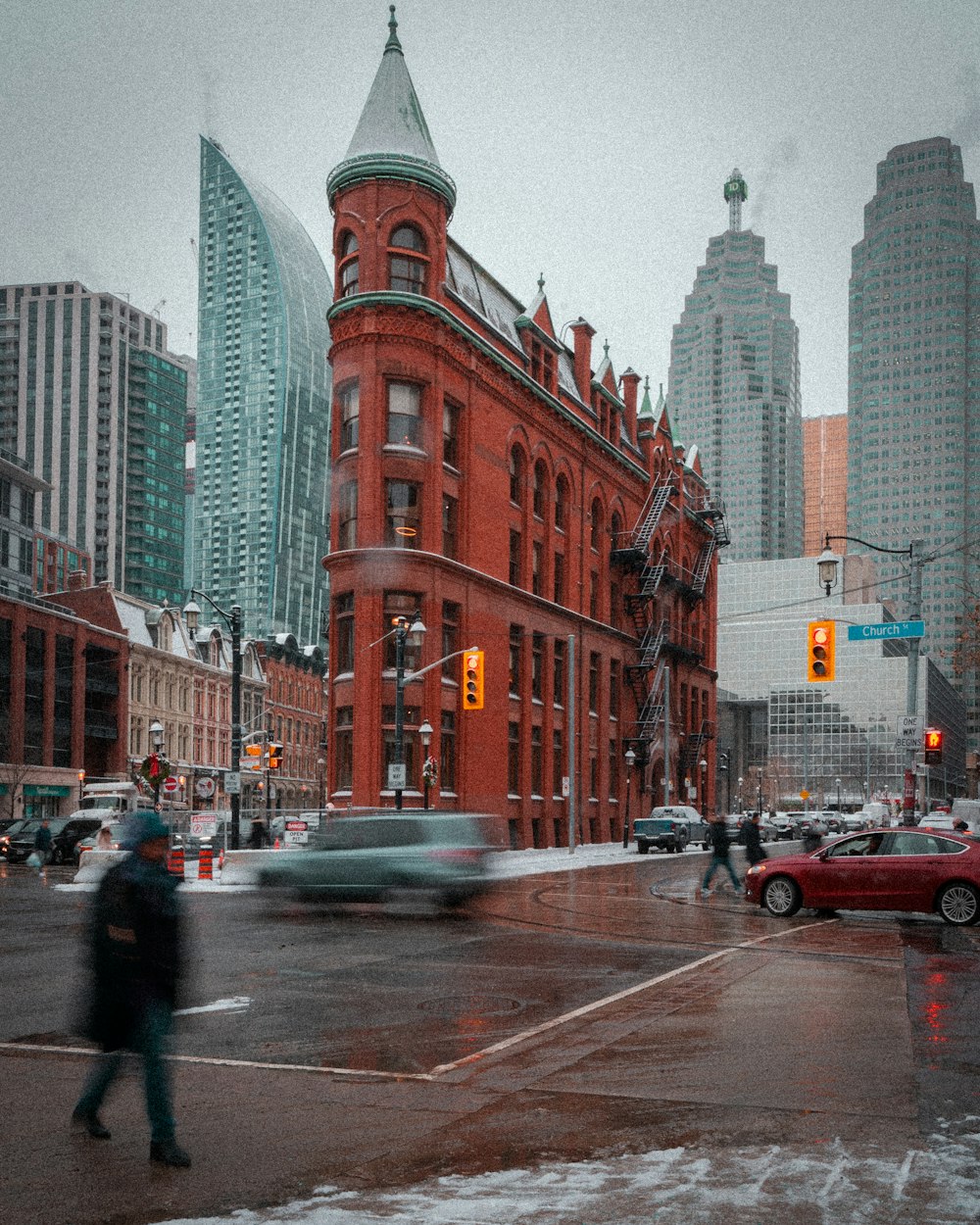 a person crossing a street in front of a red building