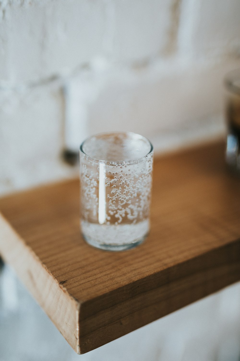 selective focus photography of clear glass on brown table