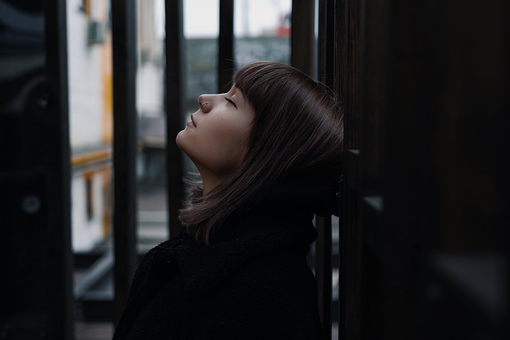 selective focus photography of woman lifting head up with eyes close