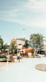 Image of a sunny day at a water park with families enjoying slides and pools.