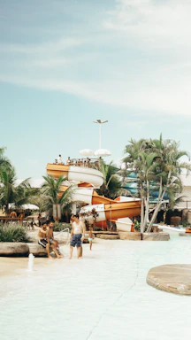 A cheerful family enjoying a sunny day at a waterpark with bright aqua blue and teal colors in the background.