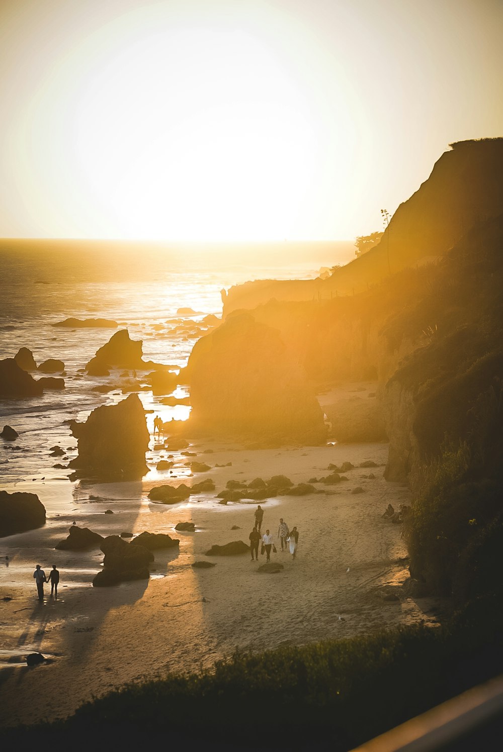 a group of people standing on top of a sandy beach