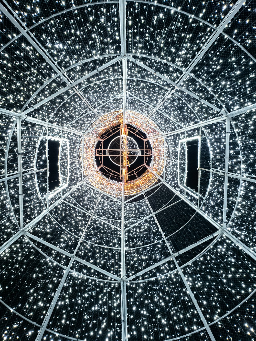 the inside of a glass structure with lights on it