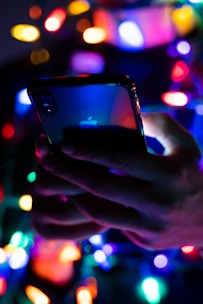 User holding an iPhone with sparkling effects shining around their face in real time.