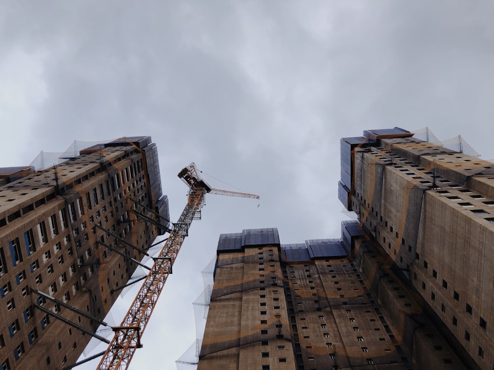 low-angle photography of building and crane
