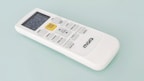 A white remote control with a digital display and several buttons, including a prominent yellow 'START/STOP' button, designed for operating an electronic device. The brand name 'marQ' is visible on the lower part of the remote. The buttons on the remote include functions for mode, swing, e-saver, timer, display, and others.