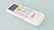A white remote control with a digital display and several buttons, including a prominent yellow 'START/STOP' button, designed for operating an electronic device. The brand name 'marQ' is visible on the lower part of the remote. The buttons on the remote include functions for mode, swing, e-saver, timer, display, and others.