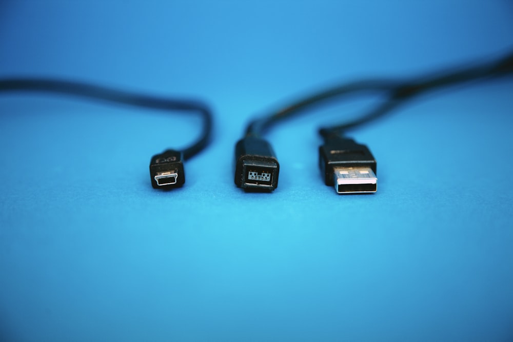 Cables USB negros sobre superficie azul