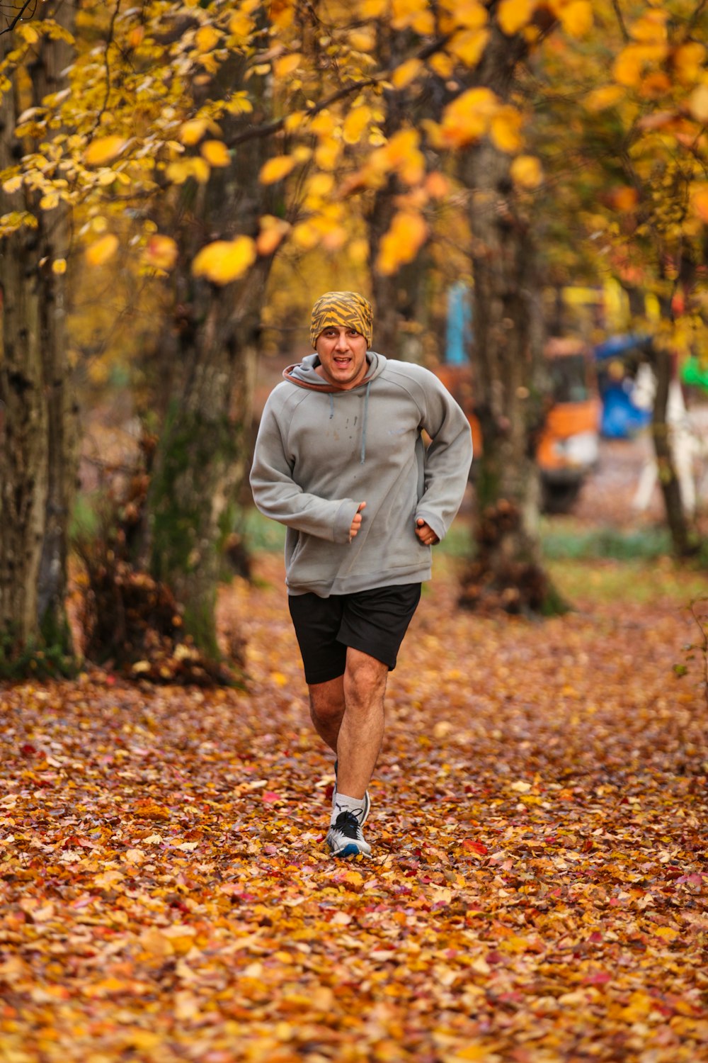 man running on leaf covered field during day