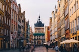 A historic European city street bustling with colorful buildings and cobblestone paths