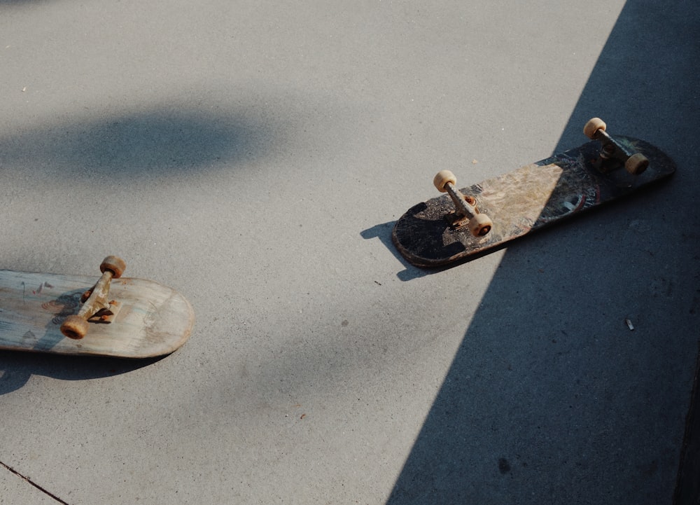 two brown skateboards on gray surface