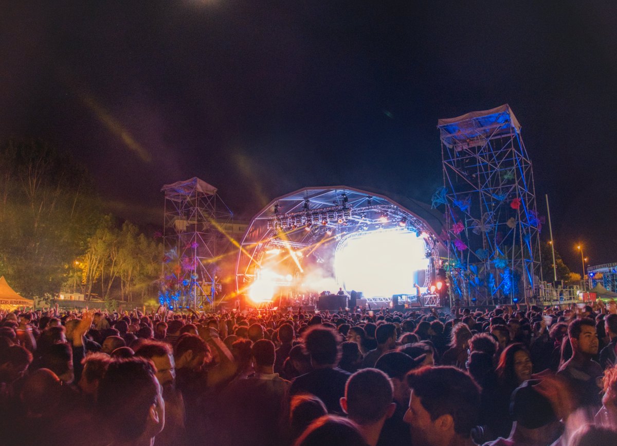 Festival stage lit at night above a dense crowd
