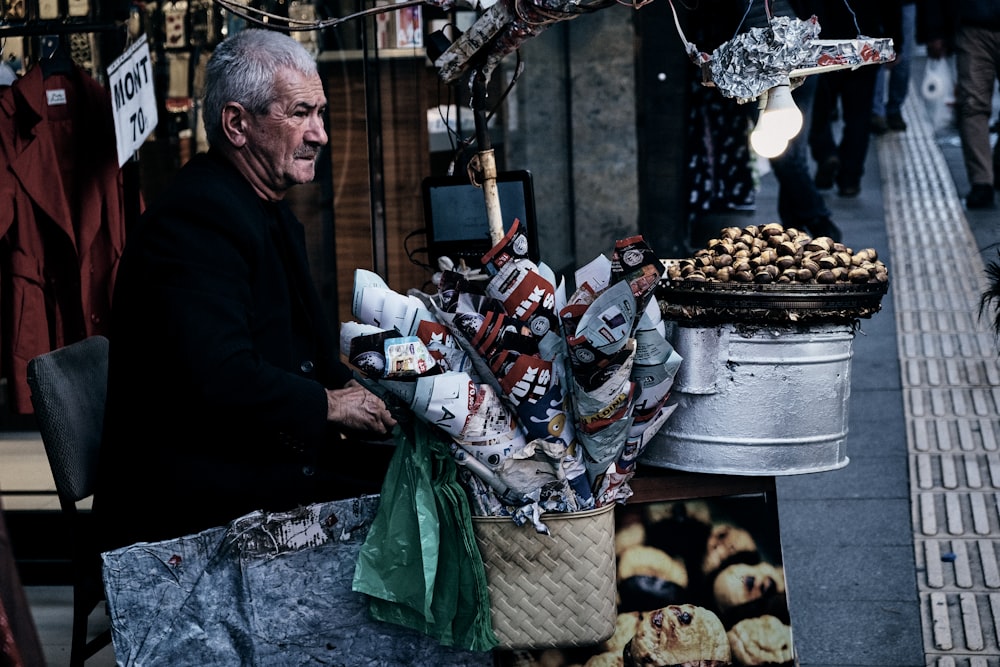 man sitting on chair holding basket with flower bouquet