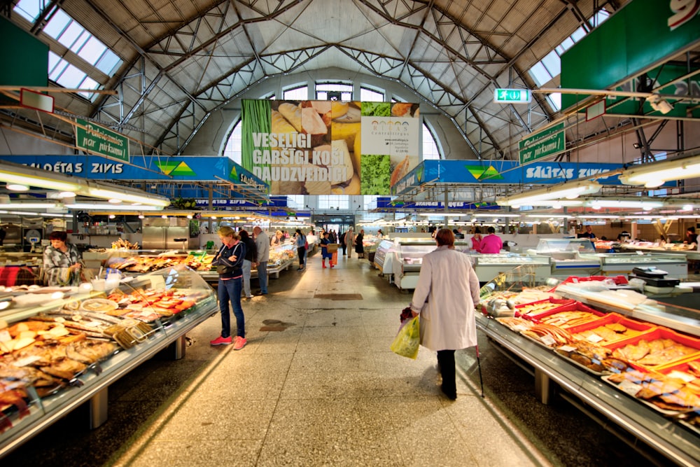 a woman is walking through a grocery store