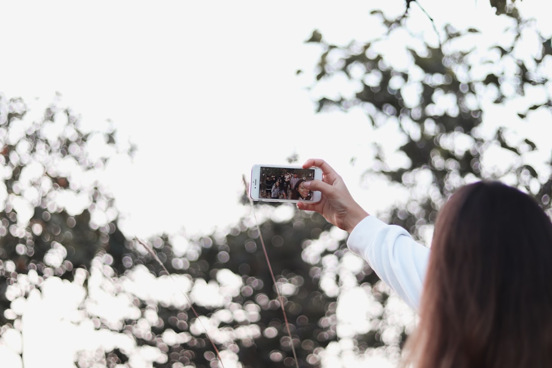 selective focus photography of person taking selfie