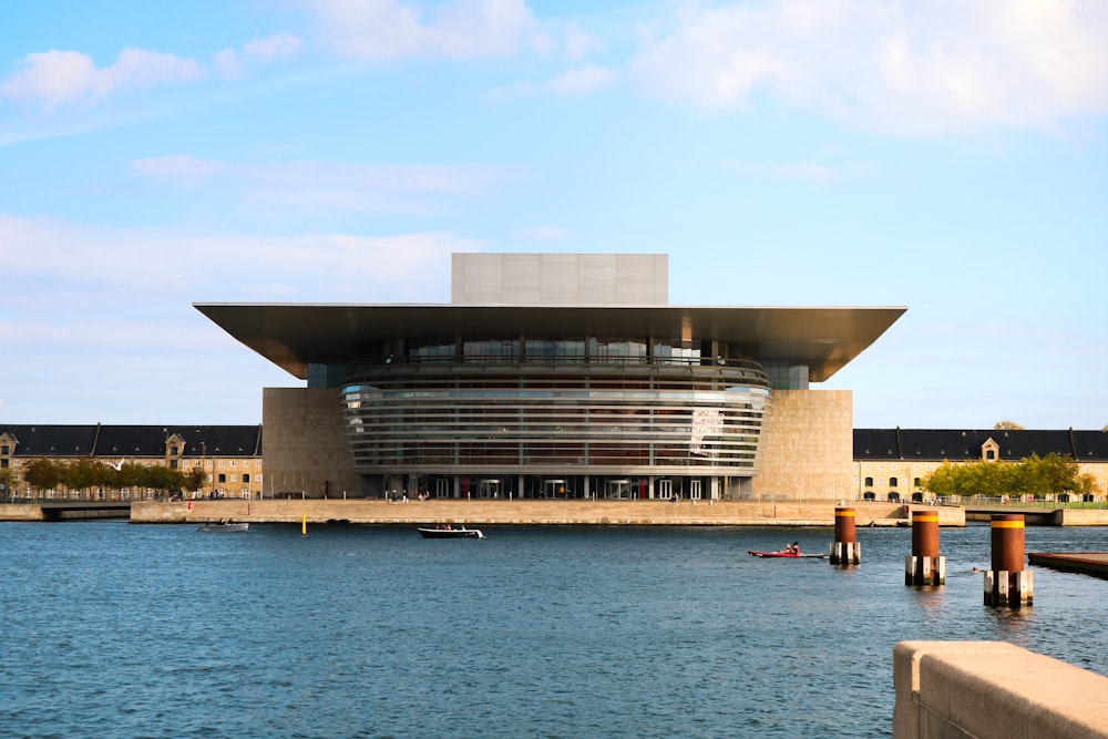 Bâtiment en béton gris à côté d’un plan d’eau pendant la journée