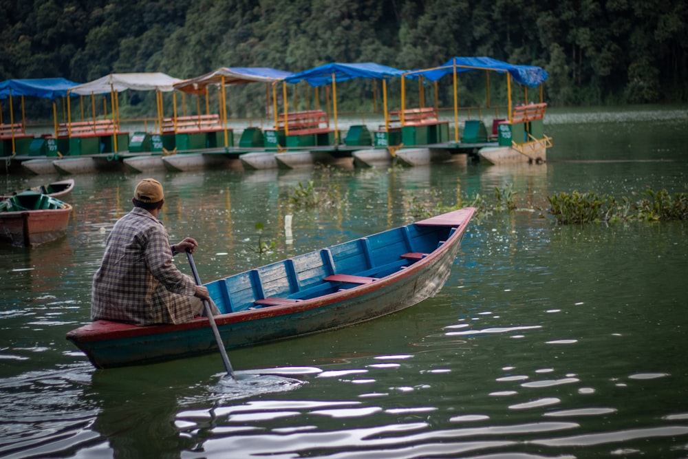 man riding on the boat holding the oar