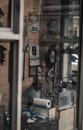 A friendly consultant assisting a small shop owner with paperwork in a cozy office setting.