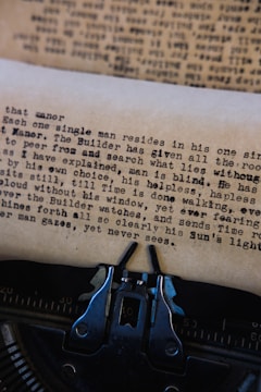 A close-up of a vintage typewriter with scattered pages.