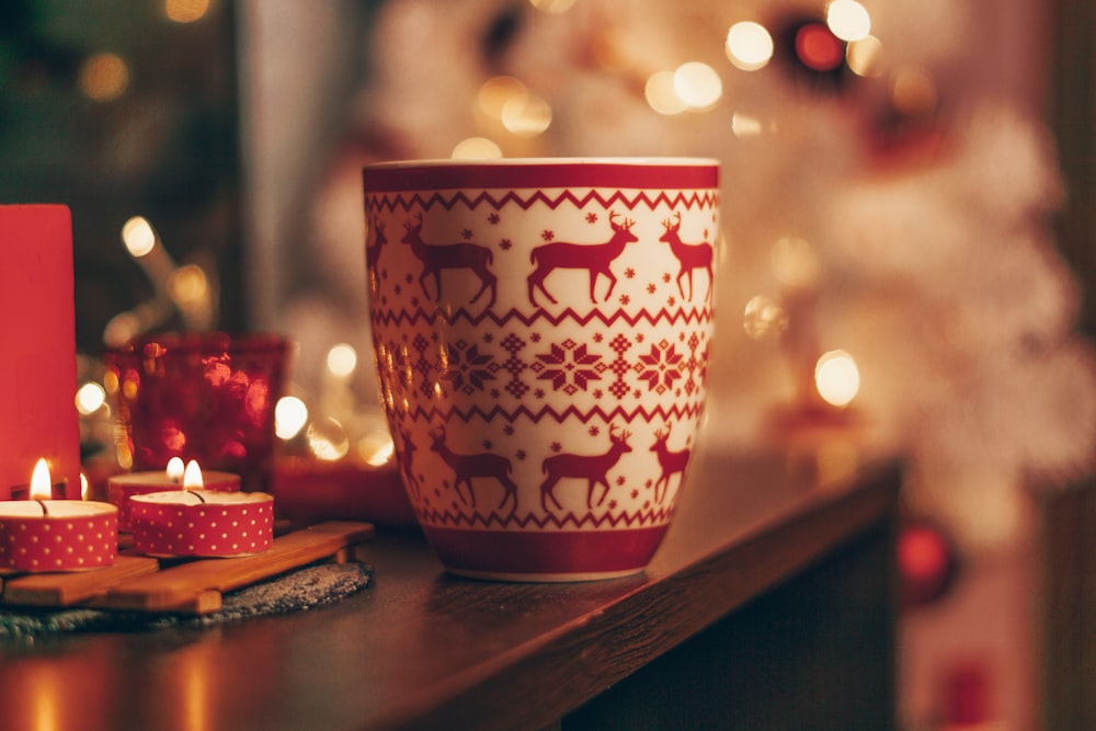 white and red deer print ceramic cup on wooden table