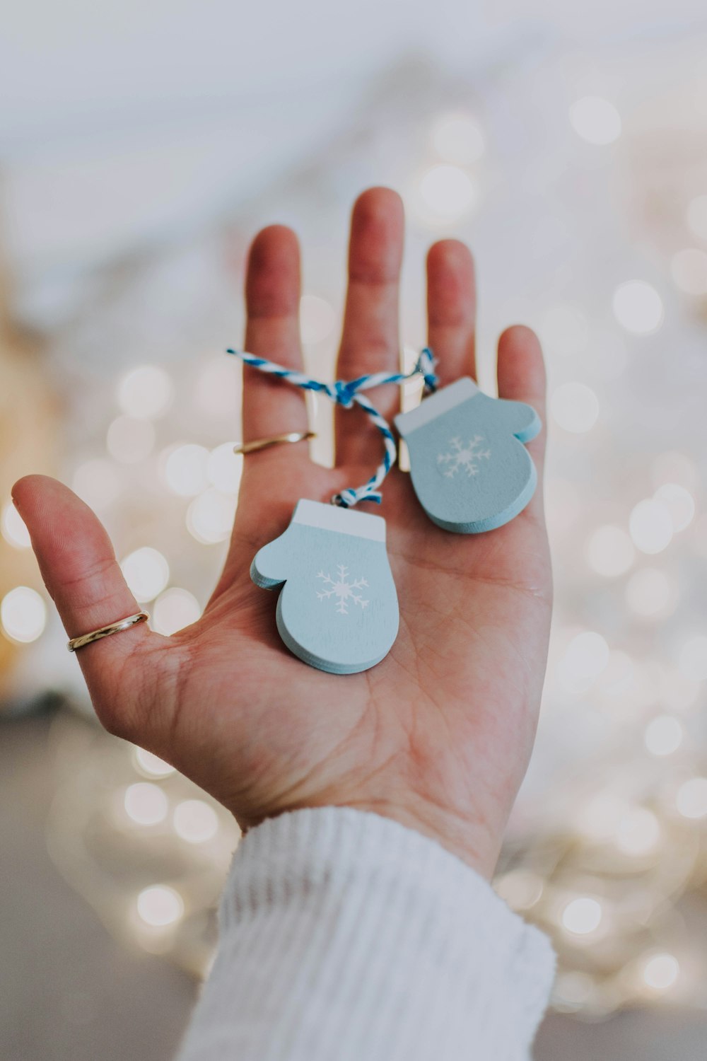 person holding blue mittens key chain