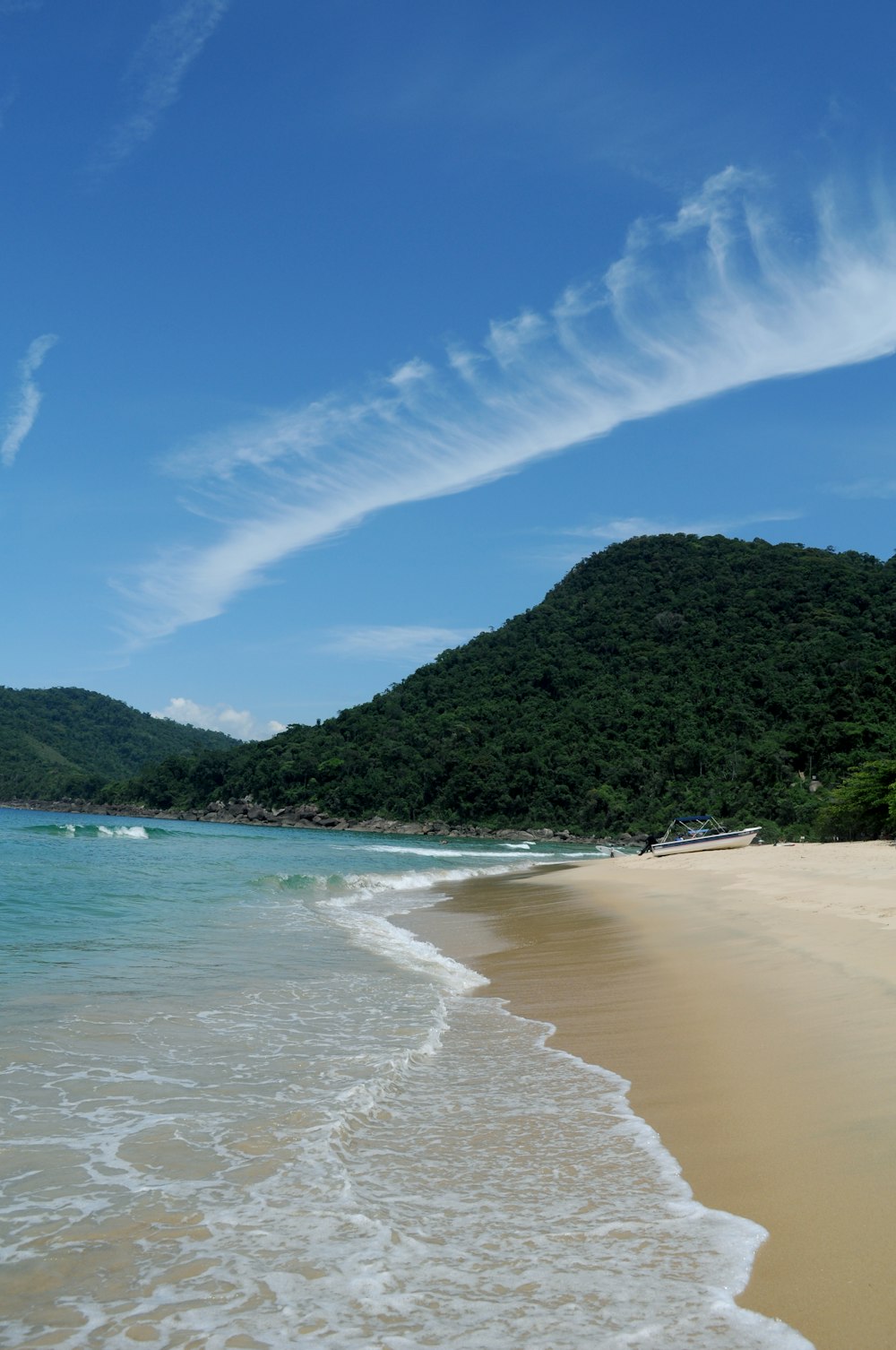 a sandy beach with a mountain in the background